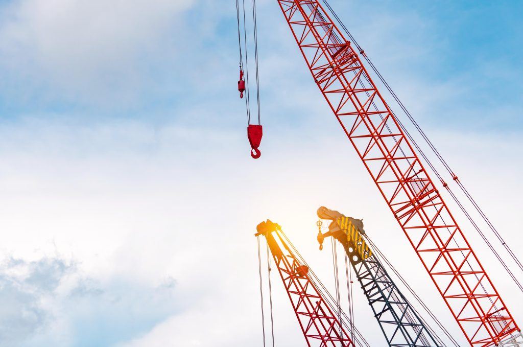 Crawler crane against blue sky and white clouds.